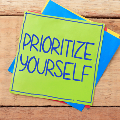 Colorful sticky notes reading 'Prioritize Yourself' on a wooden surface